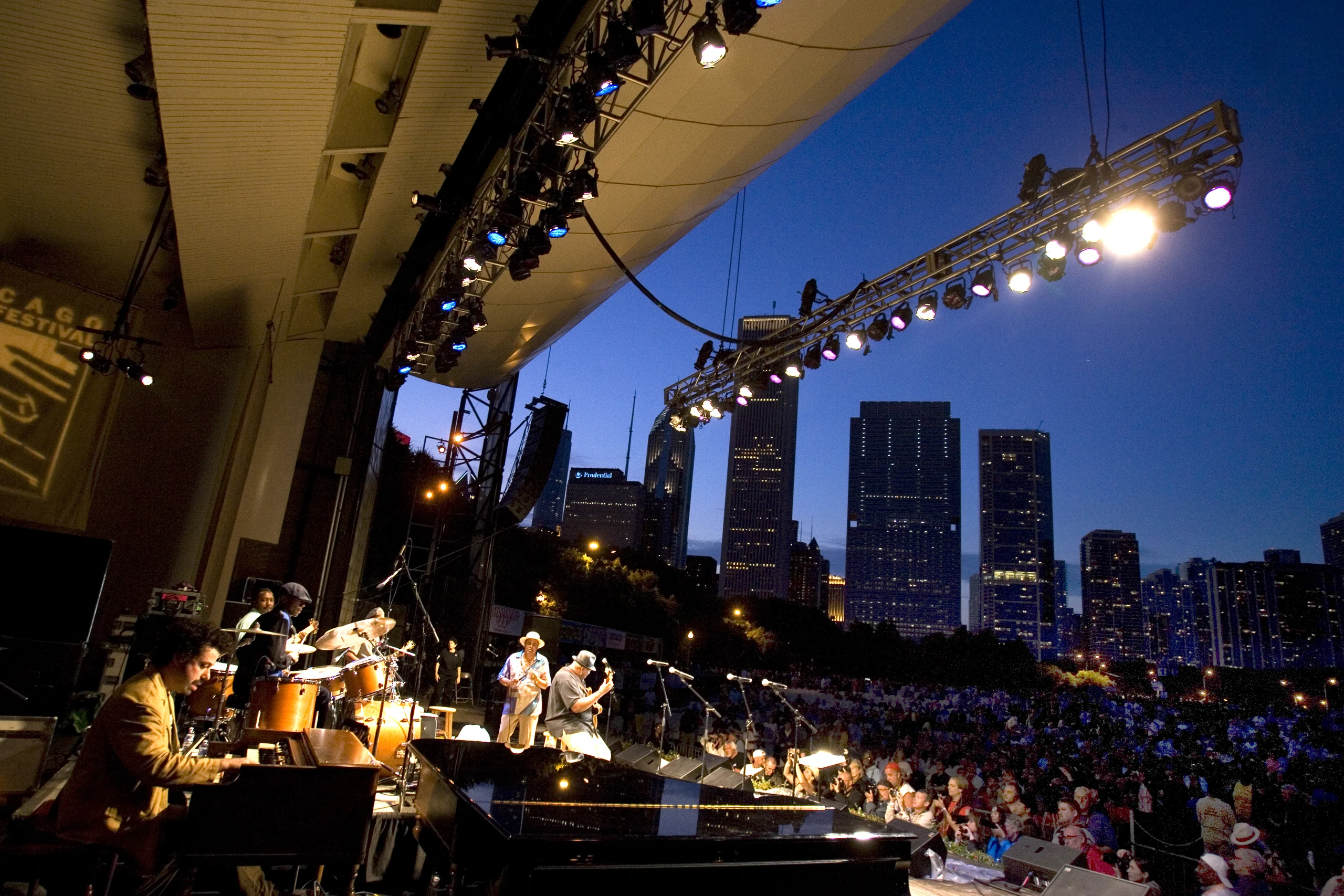 Chicago Blues artists performing at the Chicago Blues Festival with the city skyline beyond the stage