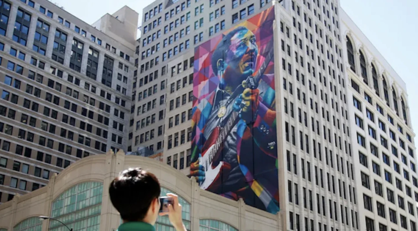 A large Blues musician mural among Chicago buildings